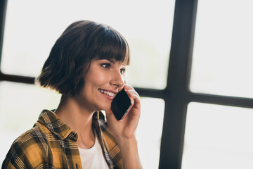 Canvas Print - Photo of cheerful shiny business woman wear checkered shirt talking modern device indoors workshop