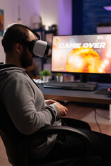 Canvas Print - Man with vr glasses playing video games with joystick on computer. Person losing game with virtual reality goggles and joystick in front of monitor. Player with online video game.