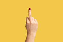 Profile Side View Closeup Of Woman Hand With Red Manicure Showing Middle Finger, Rude Gesture. Indoor Studio Shot Isolated On Yellow Background.