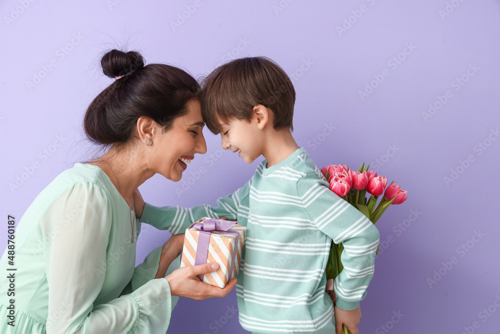Little son greeting his mother on color background