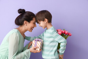 Wall Mural - Little son greeting his mother on color background