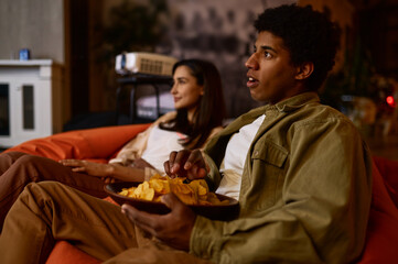 Wall Mural - Emotional young couple watching movie at home