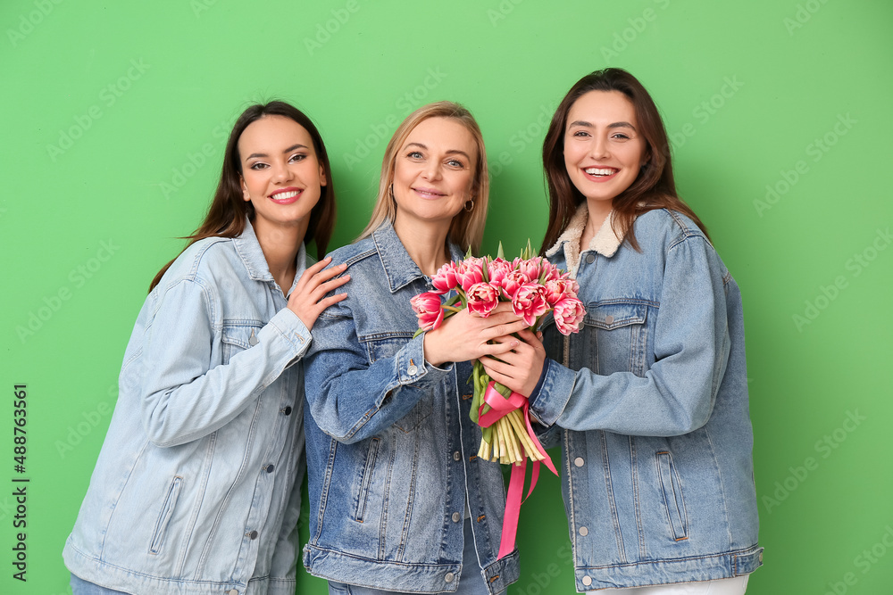 Beautiful women with flowers on green background. International Women's Day celebration