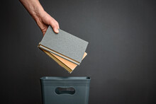 The Hand Throws Old Books Into The Trash.