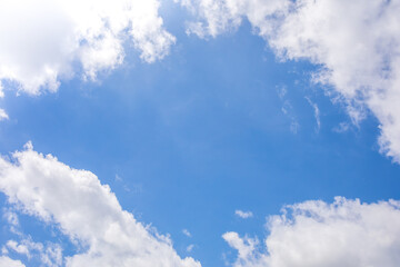 Wall Mural - blue sky and white clouds with empty copy space in the middle center.