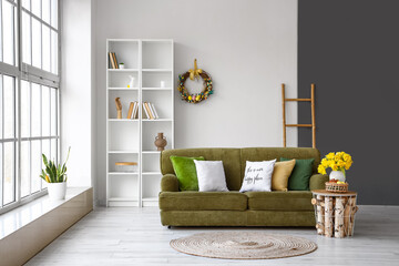 Wall Mural - Interior of living room with sofa, shelf unit and Easter wreath on light wall