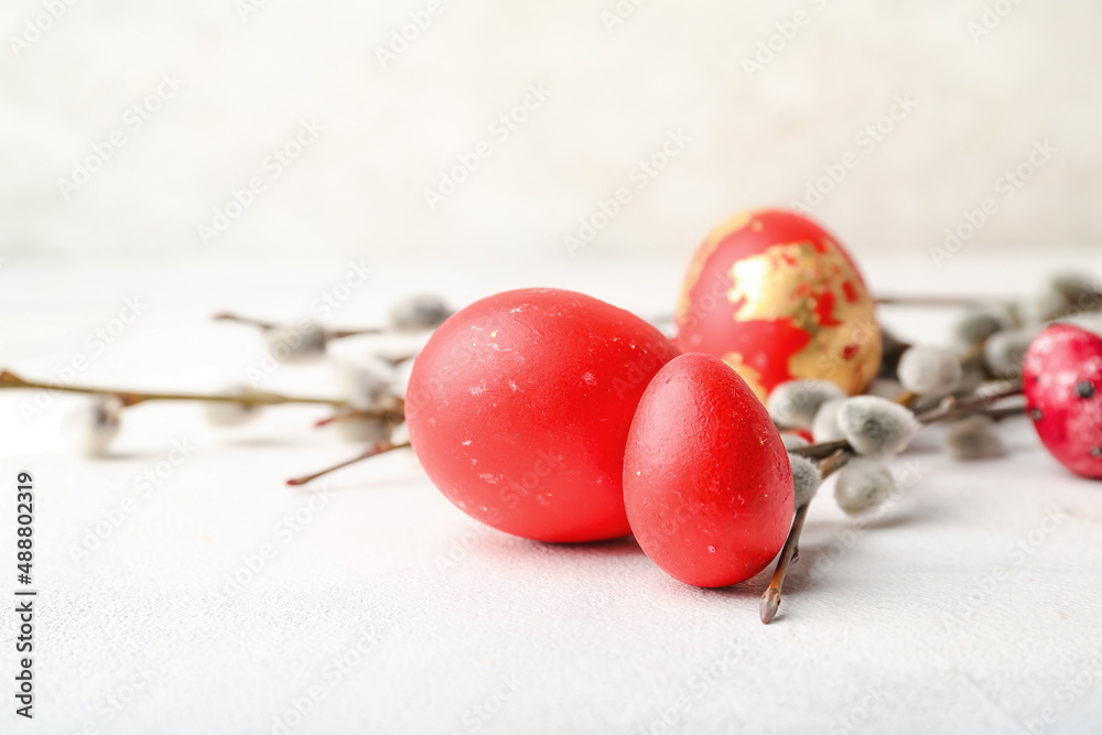 Painted Easter eggs and pussy willow branches on light background