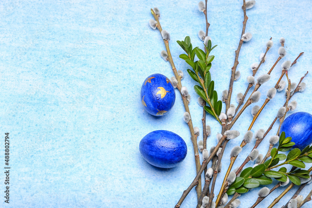 Painted Easter eggs and pussy willow branches on blue background