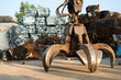 Large tracked excavator working a steel pile at a metal recycle yard. Industrial scrap metal recycling - selective focus, copy space