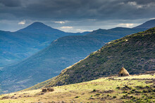 Travel To Lesotho. A Rondavel, The Traditional Hut Of Basotho Herders In A Spectacular Mountain Landscape