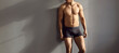 © Studio Romantic - Narrow banner shot of sexy young toned man in underwear isolated on grey studio background advertise briefs. Muscular male model in underclothing garment demonstrate good body shape.