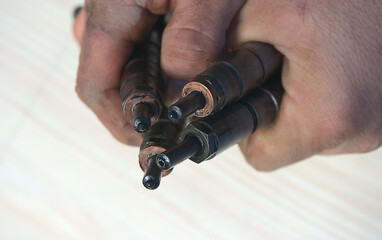 Wall Mural - Old nozzles from a diesel car in the hands of a man