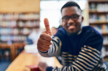 Poster - Im positive about my future. Shot of a student showing thumbs up while sitting in the library.