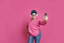 Mature Woman In Headphones Taking Selfie With Smartphone