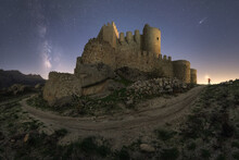 Unrecognizable Person Illuminating Ancient Castle At Night Time