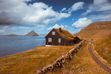 Wall Mural - foggy morning view of a house with typical turf-top grass roof in the velbastadur village on streymo