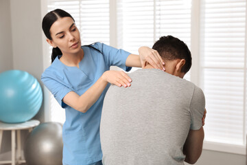 Sticker - Orthopedist examining man's neck in clinic. Scoliosis treatment