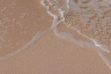 Wall Mural - Bubbles waves and sand on the beach texture background.