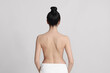 © New Africa - Back view of woman with perfect smooth skin on light background