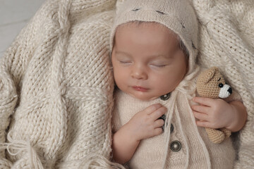 Canvas Print - Adorable newborn baby with toy bear sleeping on knitted plaid, top view