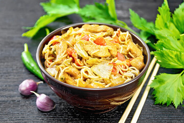 Wall Mural - Noodles with cabbage and chicken in bowl on dark board