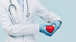 © taniasv - Female doctor in white uniform forms a heart shape with her hands. Minimal background. Banner copy space. Heart, cardiology and medical care support and assistance female health gynecology