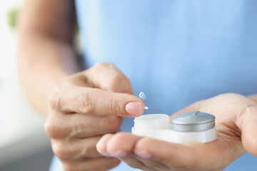 Poster - Soft contact lens with container in female hands closeup