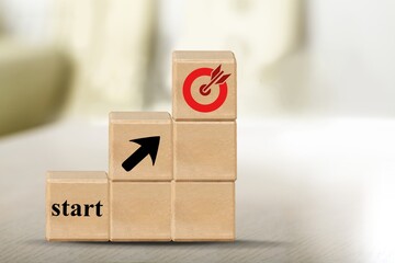 Wall Mural - Starting point and a wooden cube with an arrow pointing to the target icon. Business success concept