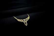 A Closeup Of A Gold Jewellery With Black Background