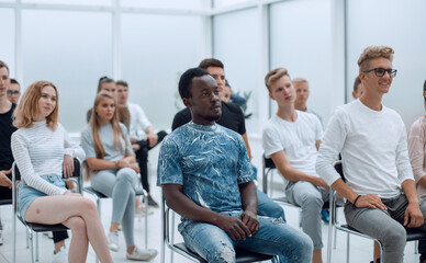 Wall Mural - diverse young people sitting on chairs in the conference room.