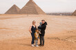 happy tourist family in Giza. holiday travel tpur near Pyramid of Khafre, Egypt. Windy weather.