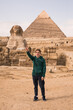 man against the background of the Egyptian pyramids. Hand up.