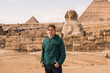 Portrait  of happy tourist  man on background pyramid of Egyptian Giza sunset, Cairo, Egypt.