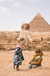 happy little girl and  boy plaing on background of Great Sphinx and Chephren's pyramid in Giza, Egypt
