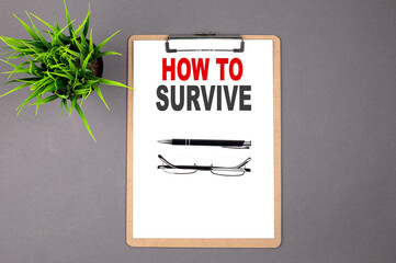 Poster - HOW TO SURVIVE on the brown clipboard on the grey background. Business concept