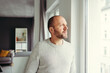 © contrastwerkstatt - Contemplative man looking through window at home