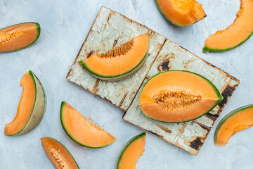 Wall Mural - cantaloupe melon. whole and slice of japanese melons, orange melon with seeds on light background. place for text, top view