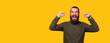 Panorama photo of an excited bearded man celebrating victory in studio.