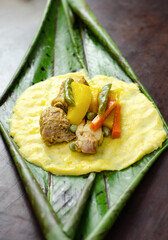 Poster - Typical Colombian and Mexican traditional dish made with corn dough and stuffed with chicken, pork, pork ribs, vegetables. rapped in banana leaves.