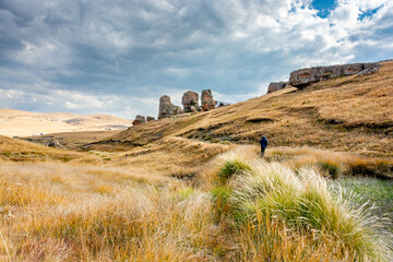 Wall Mural - Lesotho pictures. A view of boulders and a lone walker on a trail in Sethabathebe National Park