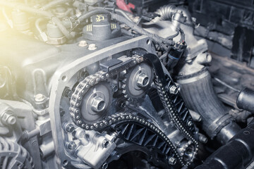 Wall Mural - New car timing chain on a diesel old engine in a car workshop. Close up. Blur effect.