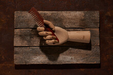 Wooden Hand With Comb On Cutting Board