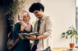 © Drazen - Happy Islamic students study together in hallway at the university.