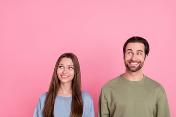 Poster - Photo of two attractive positive people toothy smile look interested empty space isolated on pink color background