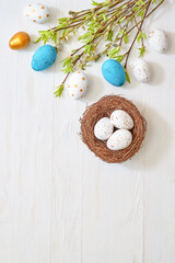 Wall Mural - branches with green leaves and easter eggs on a light background. happy easter flat lay concept