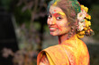 Festival of color holi, Young beautiful girl or woman or lady in indian attire saree looking back with dry organic color or colour or gulal or abeer or Holi powder on her face