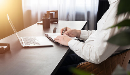 Poster - Hands taking notes, writing in planner at office desk with laptop.