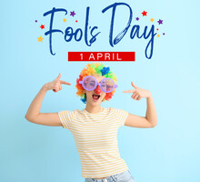 Young Woman Pointing At Funny Disguise On Blue Background. April Fools Day Celebration
