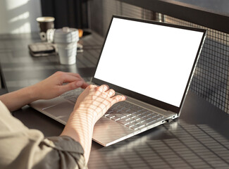 Poster - Female hands typing on laptop keyboard. Woman sitting in cafe and using computer mockup in work or study. City lifestyle concept. High quality photo