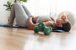 © Louis-Paul Photo - Tired African american woman working out in home livingroom gym with dumbbell in font view focus